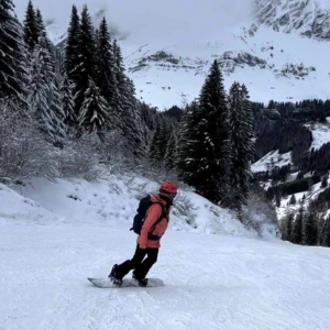 Action Outdoors' Seasonaire, Fleur, snowboarding down a ski slope in Chamonix, France